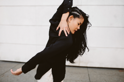 Woman bending her arm around her body.